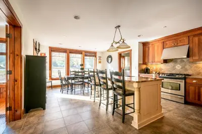 a kitchen and dining room with a table and chairs at Mt Snow Convenience! Steps from the lifts! Hot Tub in Dover