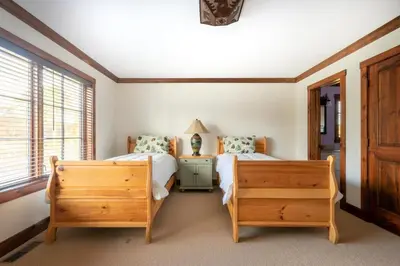 a bedroom with two twin beds and a night stand at Mt Snow Convenience! Steps from the lifts! Hot Tub in Dover