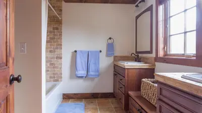 a bathroom with a tub and a sink and a mirror at Mt Snow Convenience! Steps from the lifts! Hot Tub in Dover