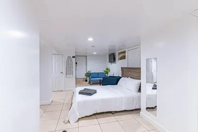 a bedroom with a white bed and a blue couch at Newark NJ Private Suite NYC Path Train in Newark