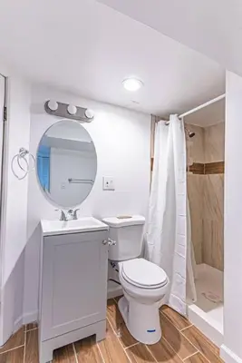 a white bathroom with a toilet and a mirror at Newark NJ Private Suite NYC Path Train in Newark