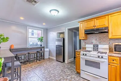 a kitchen with wooden cabinets and a white stove top oven at Newark NJ Private Suite NYC Path Train in Newark