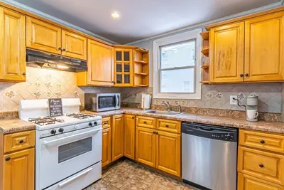 a kitchen with wooden cabinets and a white stove top oven at Newark NJ Private Suite NYC Path Train in Newark