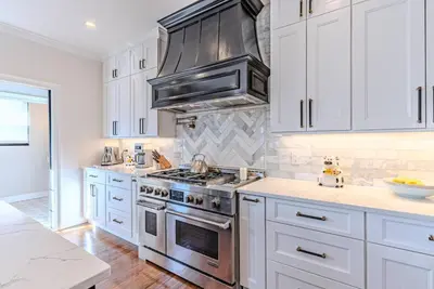 a kitchen with white cabinets and stainless steel appliances at Bergen County NYC Bus Malls in Maywood