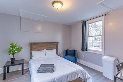 a bedroom with a bed and a chair and a window at Private BR Trains EWR USA Mall Penn Station in Newark