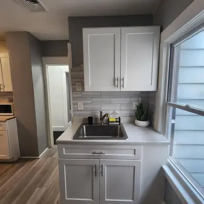 a kitchen with white cabinets and a sink at Private Bedroom In Shared Apt B in South Hackensack