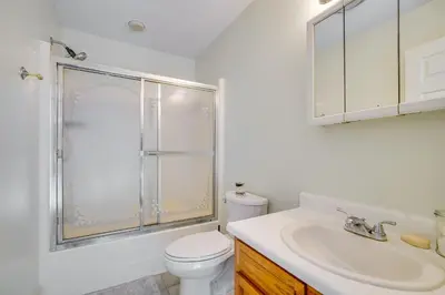 a white bathroom with a toilet and a sink at 2 Blocks to Beach Walkable Woodmont Village Home in Milford