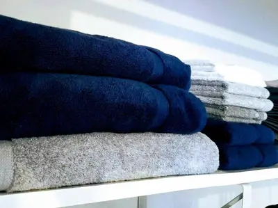 a pile of towels are stacked on a shelf at 5•Star Fave CapeCodStyle Gem with Bedroom on Main in New Britain