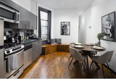 a kitchen with a table and chairs and a stove at Spacious 4Bd with Backyard in Manhattan in New York