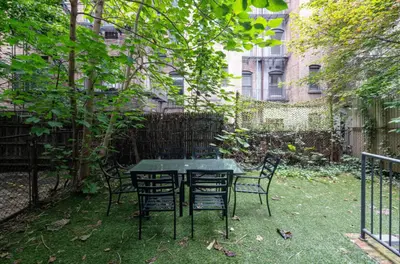 a table and chairs in a yard with a fence at Spacious 4Bd with Backyard in Manhattan in New York