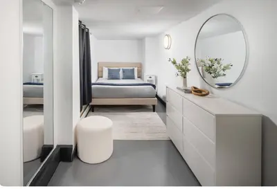 a bedroom with a bed and a mirror on the wall at Spacious 4Bd with Backyard in Manhattan in New York