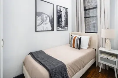 a bedroom with a bed and two pictures on the wall at Spacious 4Bd with Backyard in Manhattan in New York