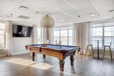 a pool table in a room with windows at Blueground Hudson Exchange pool nr Liberty Park NYC-1800 in New York