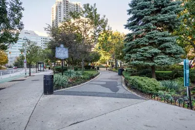 a walkway in a park with trees and bushes at Blueground Hudson Exchange pool nr Liberty Park NYC-1800 in New York