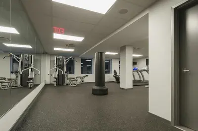 an empty gym with machines and a pole in a room at Blueground Downtown Brooklyn rooftop nr Fort Greene Park NYC-1832 in Brooklyn