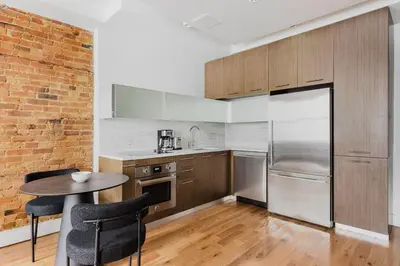 a kitchen with a table and a brick wall at Blueground Downtown Brooklyn rooftop nr Fort Greene Park NYC-1832 in Brooklyn