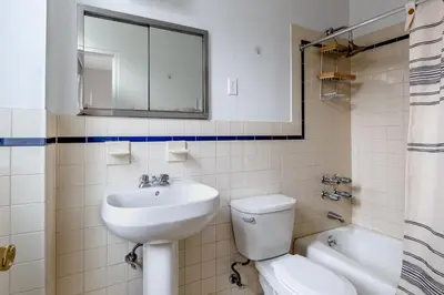 a bathroom with a sink and a toilet and a mirror at Blueground Lenox Hill view nr Central Park NYC-1303 in New York