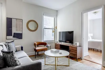 a living room with a couch and a tv at Blueground Lenox Hill view nr Central Park NYC-1303 in New York