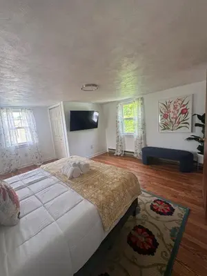 a bedroom with a large bed and a flat screen tv at Cozy Home in New Britain