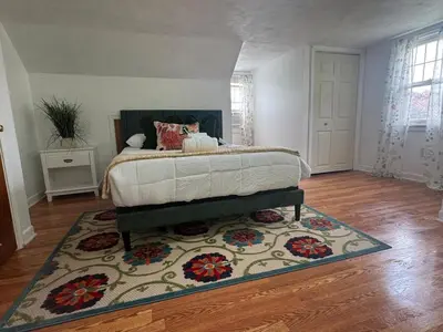 a bedroom with a bed with a rug on the floor at Cozy Home in New Britain