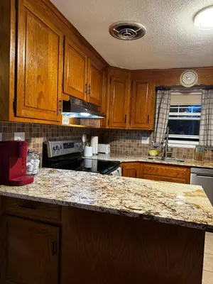 a kitchen with wooden cabinets and a granite counter top at Cozy Home in New Britain