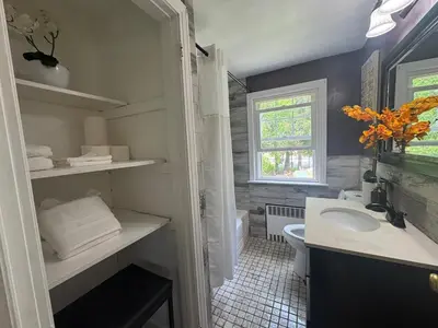 a bathroom with a sink and a toilet and a window at Cozy Home in New Britain