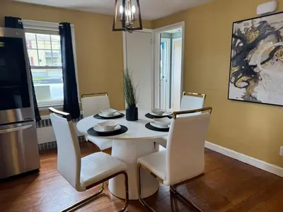 a dining room with a white table and chairs at Cozy Home in New Britain
