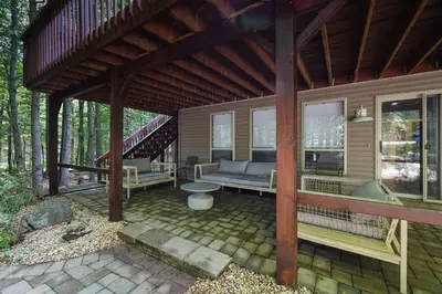 a screened in porch with a couch and a staircase at Serene Escape at Big Bass Lake & Pool Access in Clifton