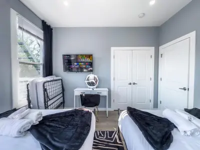 two beds in a bedroom with a desk and a chair at Stylish Secret, 1 FREE Parking, Sleeps 8, Walk to train and Red Bull Arena, 20 Percent OFF in Harrison