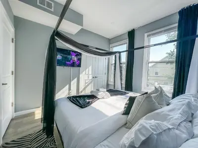 a bedroom with a white bed and a window at Stylish Secret, 1 FREE Parking, Sleeps 8, Walk to train and Red Bull Arena, 20 Percent OFF in Harrison