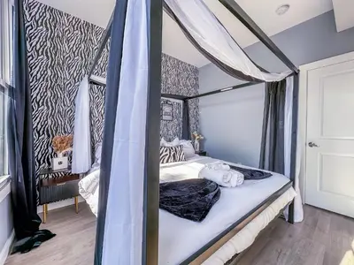a bedroom with a canopy bed in a room at Stylish Secret, 1 FREE Parking, Sleeps 8, Walk to train and Red Bull Arena, 20 Percent OFF in Harrison