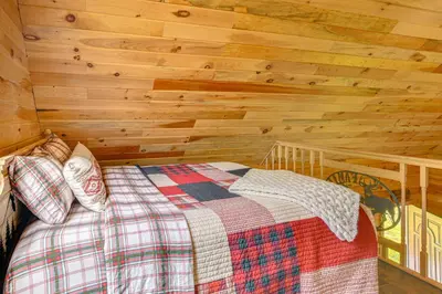 a bedroom with a bed in a wooden wall at Escape to Nature Secluded McDonough Cabin!