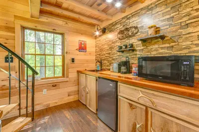 a kitchen with a counter with a microwave and a stove at Escape to Nature Secluded McDonough Cabin!