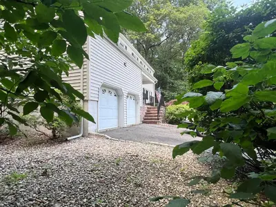 a white house with a garage with a driveway at Cozy Budd Lake Cul-de-Sac Home Lodge in Mount Olive