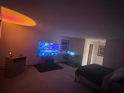 a bedroom with a large screen tv in a dark room at Cozy Budd Lake Cul-de-Sac Home Lodge in Mount Olive