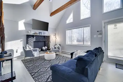 a living room with a blue couch and a fireplace at The Cozy Modern Cabin Ski & Relax in Tobyhanna