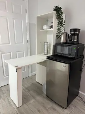 a kitchen with a white desk and a microwave at Ultra Contemporary Loft in Scarsdale