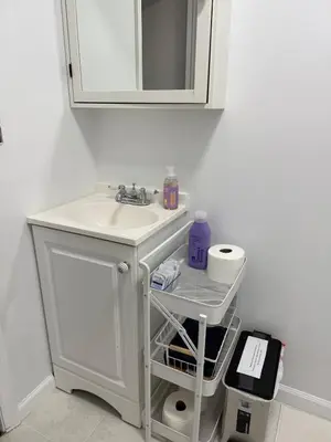 a white bathroom with a sink and a mirror at Ultra Contemporary Loft in Scarsdale
