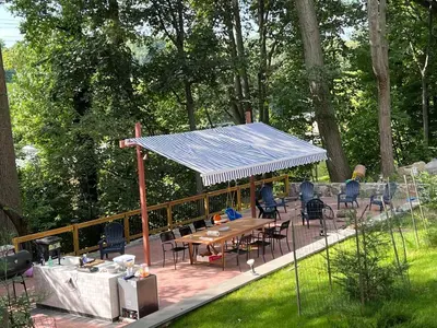 a patio with a blue roof with tables and chairs at Ultra Contemporary Loft in Scarsdale