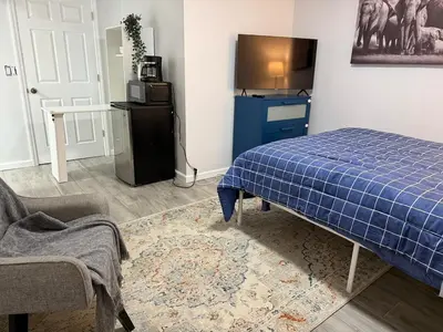 a bedroom with a blue bed and a tv at Ultra Contemporary Loft in Scarsdale