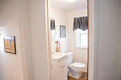 a white bathroom with a toilet and a sink at The Farmhouse at Deer Run