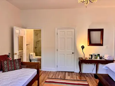 a bedroom with a bed and a bathroom with a sink at private spacious apartment with 2 bedrooms 2 bathroomss and a deck in New York