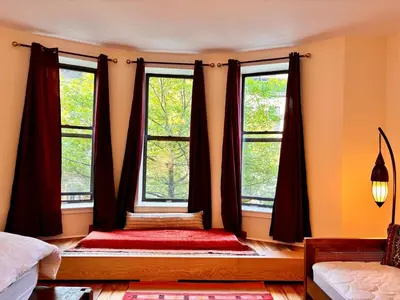 a bedroom with two windows and a red rug at private spacious apartment with 2 bedrooms 2 bathroomss and a deck in New York