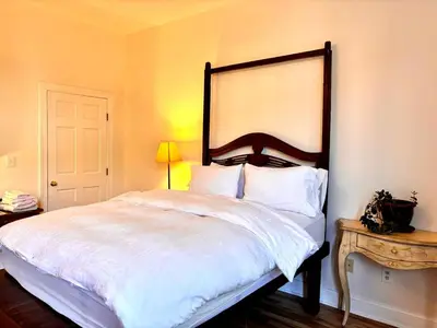 a bedroom with a large white bed and a table at private spacious apartment with 2 bedrooms 2 bathroomss and a deck in New York
