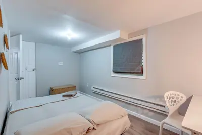 a white bedroom with a bed and a window at Game Room and Deck Family Home in Tobyhanna! in Tobyhanna