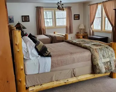 a bedroom with a wooden bed in a room at Serendipity Lake House in Windham