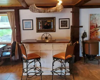 a bar in a room with chairs and a mirror at Serendipity Lake House in Windham