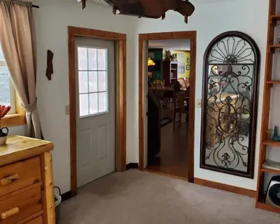 a living room with a door and a mirror at Serendipity Lake House in Windham