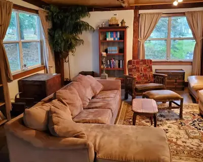 a living room with a large brown couch and chairs at Serendipity Lake House in Windham