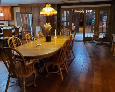 a wooden table with chairs and a dining room at Serendipity Lake House in Windham